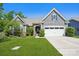 Charming home with stone accents, well-manicured lawn, and a two-car garage with a blue sky in the background at 16427 Cozy Cove Rd, Charlotte, NC 28278
