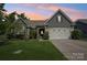 Charming home exterior with manicured lawn, stone accents, and a welcoming two-car garage at 16427 Cozy Cove Rd, Charlotte, NC 28278