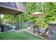 Backyard patio features an outdoor dining and seating area, artificial grass, and beautiful green surroundings at 16427 Cozy Cove Rd, Charlotte, NC 28278