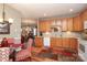 A kitchen featuring wooden cabinetry, a white dishwasher, and an adjacent dining area at 2114 N Castle Ct, Matthews, NC 28105