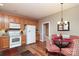 Bright kitchen with wooden cabinets, white appliances, and an adjacent dining area at 2114 N Castle Ct, Matthews, NC 28105