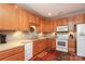 The kitchen is equipped with wood cabinets, white appliances and ample counter space at 2114 N Castle Ct, Matthews, NC 28105