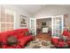 Bright sunroom with neutral walls, red sofas, and open doorway to the living room at 2114 N Castle Ct, Matthews, NC 28105