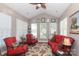 Bright sunroom with vaulted ceiling, large windows, and comfortable red seating arrangement at 2114 N Castle Ct, Matthews, NC 28105