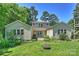 Charming backyard with lush lawn, mature trees, and unique architectural details with a fire pit at 2115 Mecklenburg Ave, Charlotte, NC 28205
