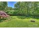 Lush backyard with vibrant garden beds, mature trees, and a well-maintained lawn, creating a private retreat at 2115 Mecklenburg Ave, Charlotte, NC 28205