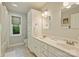 Bathroom featuring double vanities with white countertops, tile floor, and a window at 2115 Mecklenburg Ave, Charlotte, NC 28205