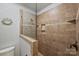 Shower with glass enclosure featuring tile surround with accent trim and built-in shelving at 2115 Mecklenburg Ave, Charlotte, NC 28205