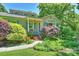Inviting home with lush landscaping, a brick walkway, and quaint blue shutters at 2115 Mecklenburg Ave, Charlotte, NC 28205