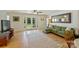 Bright living area with a large green sectional, hardwood floors, and French doors to the garden at 2115 Mecklenburg Ave, Charlotte, NC 28205