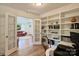 Office featuring built-in shelving filled with decor, view into the living room with a red sofa at 2115 Mecklenburg Ave, Charlotte, NC 28205