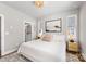 Cozy bedroom with a plush queen bed, stylish chandelier, neutral decor, and large windows, creating a serene retreat at 2123 Bryant Park Dr, Charlotte, NC 28208