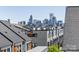 View of Charlotte skyline from rooftop patio with gray roofing and siding in a modern townhome community on a clear day at 2123 Bryant Park Dr, Charlotte, NC 28208