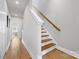 Hallway with wood floors leading to staircase with natural wood handrail at 2123 Bryant Park Dr, Charlotte, NC 28208