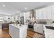 Bright kitchen with white cabinets, quartz countertops, stainless steel appliances, an island, and wood flooring at 2123 Bryant Park Dr, Charlotte, NC 28208
