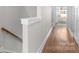 Hallway featuring hardwood floors, modern trim and wall paint with views into a living space with a rocking chair at 2123 Bryant Park Dr, Charlotte, NC 28208
