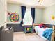 Cozy bedroom with a colorful dartboard, blue curtains, and a daybed at 217 Hickory Dr, Mooresville, NC 28115