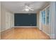 Spacious bedroom featuring hardwood floors, a ceiling fan, natural light from the window, and a blue accent wall at 2235 Ramblewood Ln, Charlotte, NC 28210