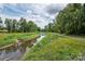 Picturesque creek with lush vegetation and walking path, perfect for a peaceful stroll surrounded by nature at 2235 Ramblewood Ln, Charlotte, NC 28210