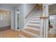 Inviting foyer with wooden stairs, hardwood floors, and a glimpse of a half bathroom near the front door at 2235 Ramblewood Ln, Charlotte, NC 28210