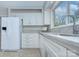 Updated kitchen with white cabinets, granite countertops, and tile flooring at 2235 Ramblewood Ln, Charlotte, NC 28210