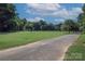 Expansive community soccer field with green grass, mature trees, and walking path, great for outdoor sports at 2235 Ramblewood Ln, Charlotte, NC 28210
