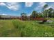 Walking bridge over green space, with lush vegetation and blue skies, and a bike parked alongside, perfect for nature walks at 2235 Ramblewood Ln, Charlotte, NC 28210