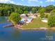 Aerial view of lakeside home featuring a pool, pier, and backyard at 235 River Loop Rd, Belmont, NC 28012
