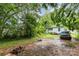 Backyard featuring an expanse of greenery, a parked car, and lawn maintenance equipment at 2622 Hemphill St, Charlotte, NC 28208