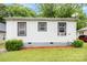 Exterior shot showing white siding with black trim windows, complemented by green shrubbery at 2622 Hemphill St, Charlotte, NC 28208