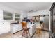 Kitchen featuring white cabinets, stainless steel refrigerator, and island with chairs at 2622 Hemphill St, Charlotte, NC 28208