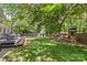 Large backyard with lush green grass, wooden deck, play set, and mature trees creating a private oasis at 301 Deer Creek Dr, Matthews, NC 28105