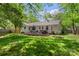 Spacious backyard with wooden deck featuring outdoor seating, swing, fire pit, and lush greenery creating a relaxing retreat at 301 Deer Creek Dr, Matthews, NC 28105