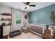 Comfortable Bedroom with chair, crib, window with natural light, and teal accent wall at 301 Deer Creek Dr, Matthews, NC 28105