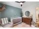Bedroom with stylish modern decor, crib, dresser, and teal accent wall at 301 Deer Creek Dr, Matthews, NC 28105