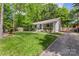 Charming home with lush green lawn, trees, and a long paved driveway at 301 Deer Creek Dr, Matthews, NC 28105