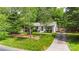 Charming white home with lush green lawn and mature trees in front yard at 301 Deer Creek Dr, Matthews, NC 28105