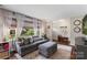 Cozy living room filled with natural light and furnished with a comfortable gray couch and large windows at 301 Deer Creek Dr, Matthews, NC 28105