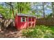 Small red shed with a window and a white trim in a fenced backyard at 301 Deer Creek Dr, Matthews, NC 28105