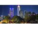 Nighttime view of the Charlotte skyline showing colorful lights and trees in foreground at 301 W 10Th W St, Charlotte, NC 28202