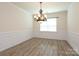 Formal dining room featuring wainscoting, decorative chandelier, and wood flooring at 309 Kentmere Ln, Clover, SC 29710