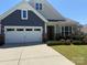 Charming home featuring a two-car garage, stone accents and manicured lawn at 309 Kentmere Ln, Clover, SC 29710