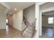Inviting hallway with wood-look floors, stairs with dark wood railings and an open doorway at 309 Kentmere Ln, Clover, SC 29710