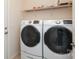 Well-equipped laundry room with modern washer and dryer units and built-in shelving above at 309 Kentmere Ln, Clover, SC 29710