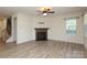 Cozy living room features a decorative fireplace, modern ceiling fan, and large windows for natural light at 309 Kentmere Ln, Clover, SC 29710