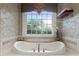 Soaking tub with a view and decorator wallpaper in a bathroom with decorator wallpaper at 3314 Leamington Ln, Charlotte, NC 28226