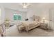 A luxurious bedroom with a tufted headboard, plush bedding, and a sitting area near a window at 3314 Leamington Ln, Charlotte, NC 28226