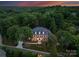 Majestic home surrounded by lush trees at dusk, offering a serene and private setting at 3314 Leamington Ln, Charlotte, NC 28226