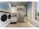 Bright laundry room featuring a large refrigerator, washer and dryer, and custom wall art at 3314 Leamington Ln, Charlotte, NC 28226