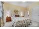 Charming bedroom features floral bedding, bedside tables, and a view to an adjoining room at 3508 Mountain Cove Dr, Charlotte, NC 28216